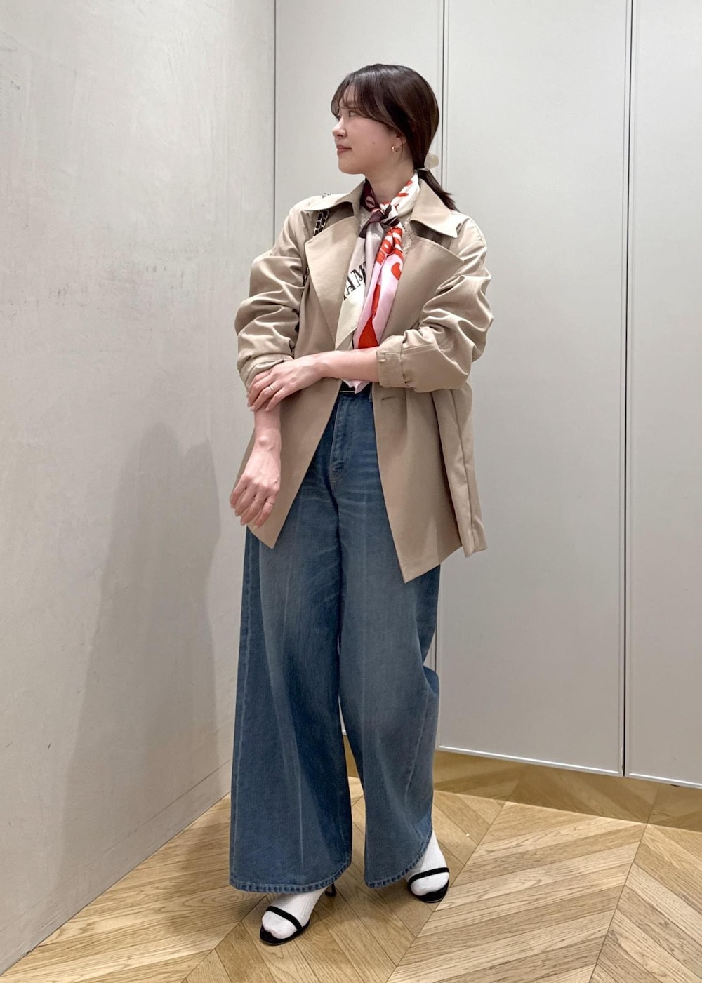 ブラック系のハンドバッグ、ホワイト系のニット/セーター、ブルー系のデニムパンツを着用したレディースの春コーディネートの2枚目の写真