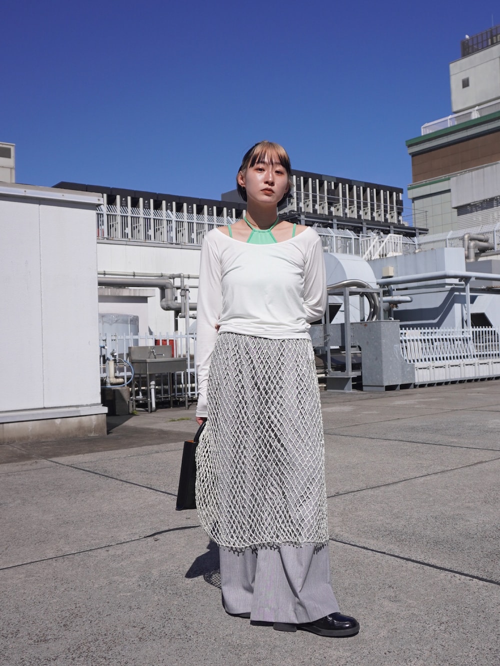 グリーン系のTシャツ/カットソー、ホワイト系のスカートを着用したレディースの春コーディネートの2枚目の写真