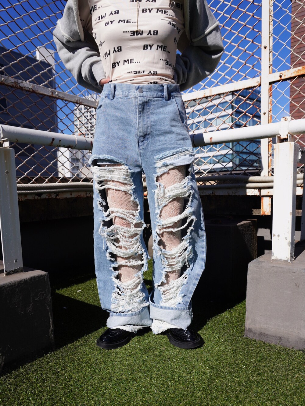 グレー系のスウェット、ブルー系のデニムパンツを着用したレディースの秋コーディネートの3枚目の写真