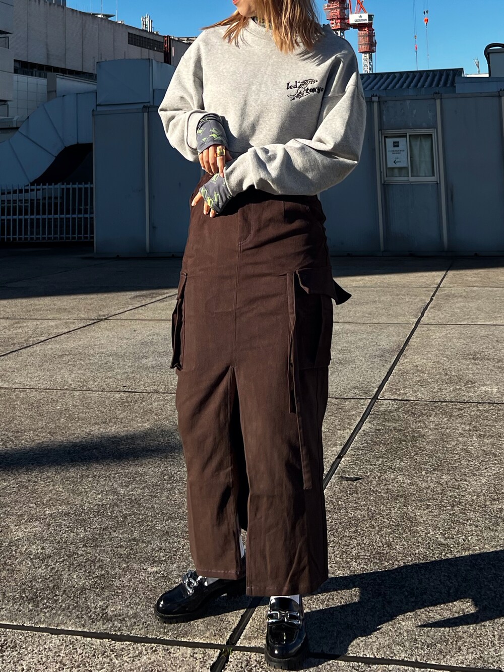 グレー系のスウェット、グレー系のその他トップス、ブラウン系のスカートを着用したレディースの冬コーディネートの2枚目の写真