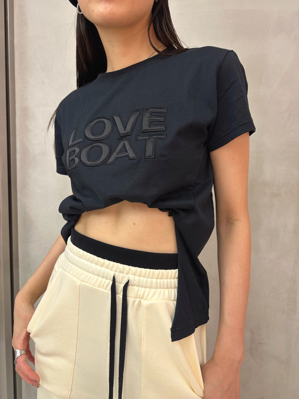 ホワイト系のスウェットパンツ、ブラック系のTシャツ/カットソーを着用したレディースの春コーディネートの2枚目の写真