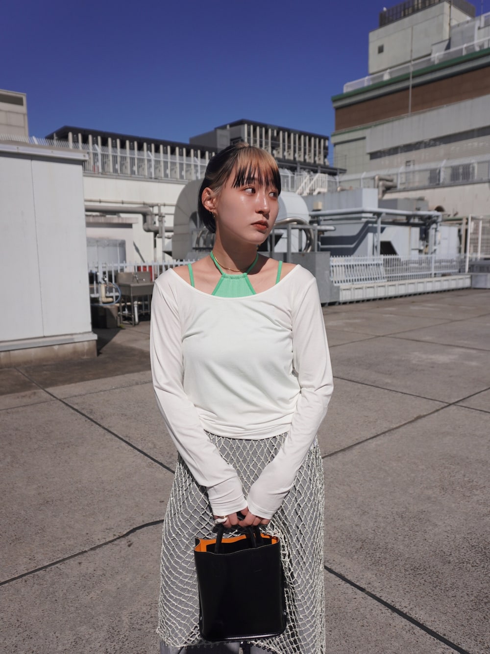 グリーン系のTシャツ/カットソー、ホワイト系のスカートを着用したレディースの春コーディネートの3枚目の写真