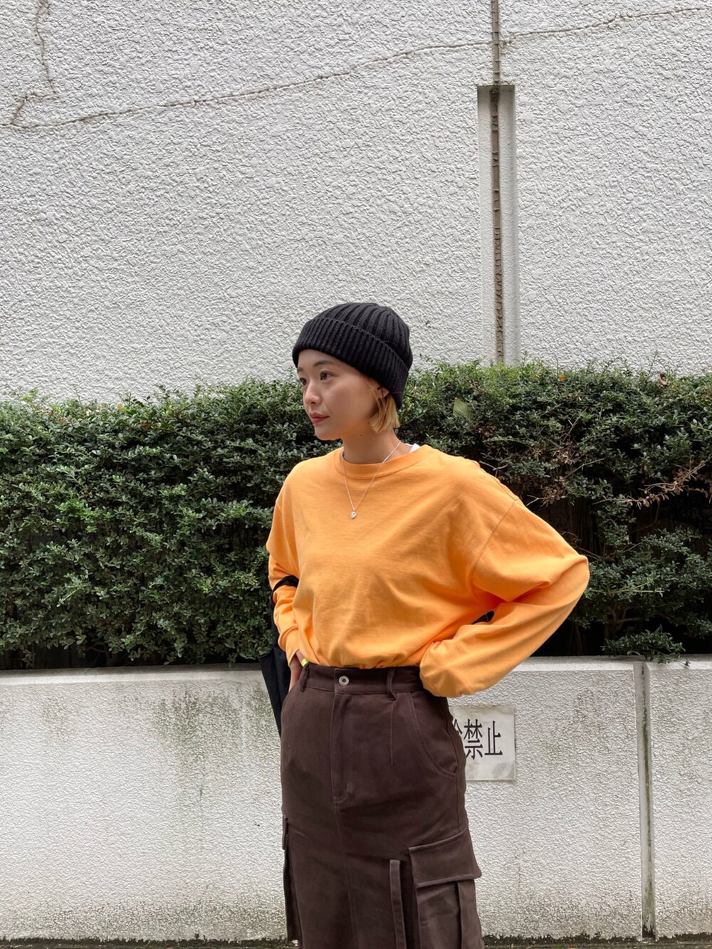 ブラウン系のスカートを着用したレディースの秋コーディネートの2枚目の写真