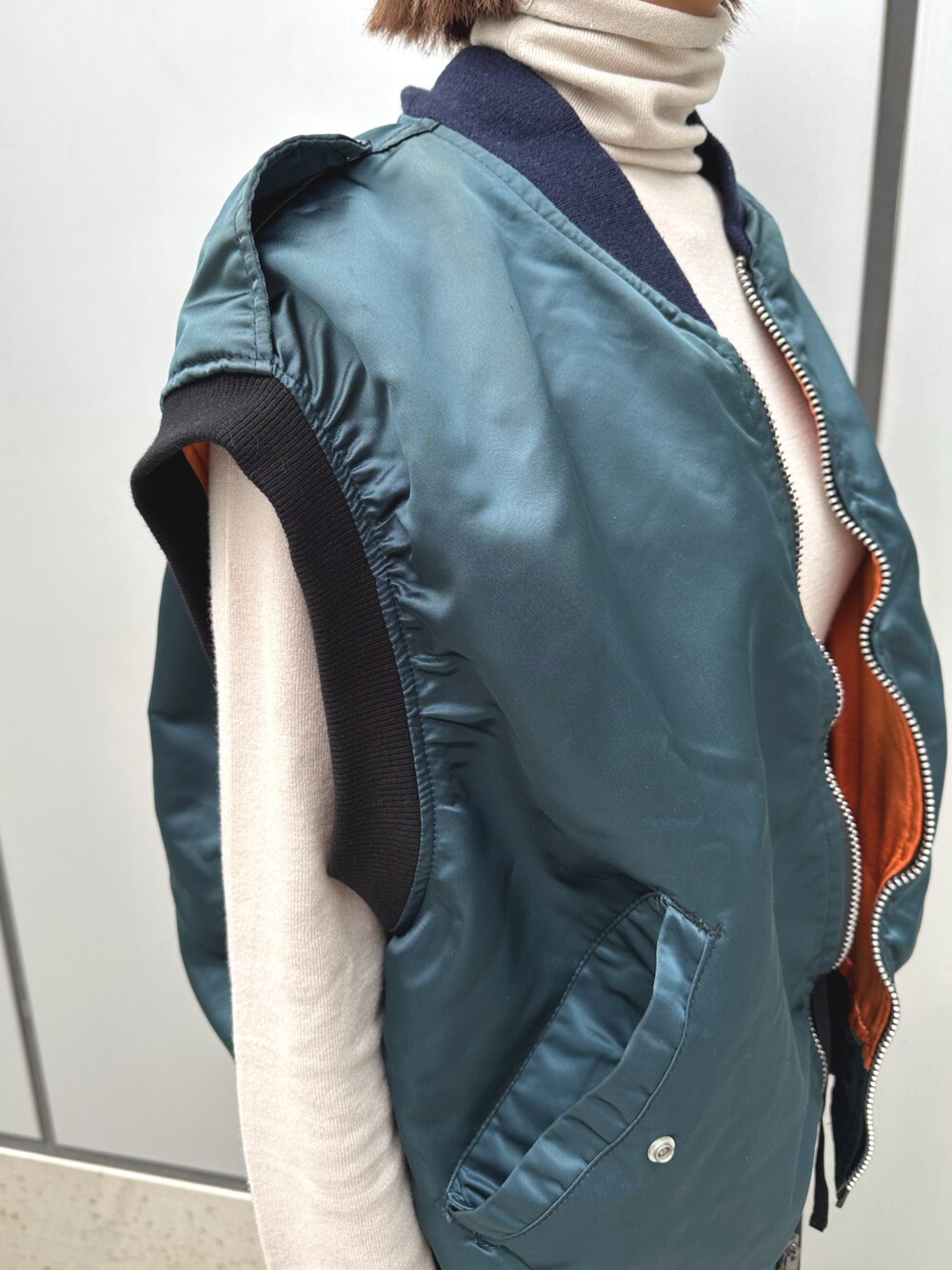 グリーン系のブルゾン、ブラック系のカーゴパンツを着用したレディースの春コーディネートの2枚目の写真