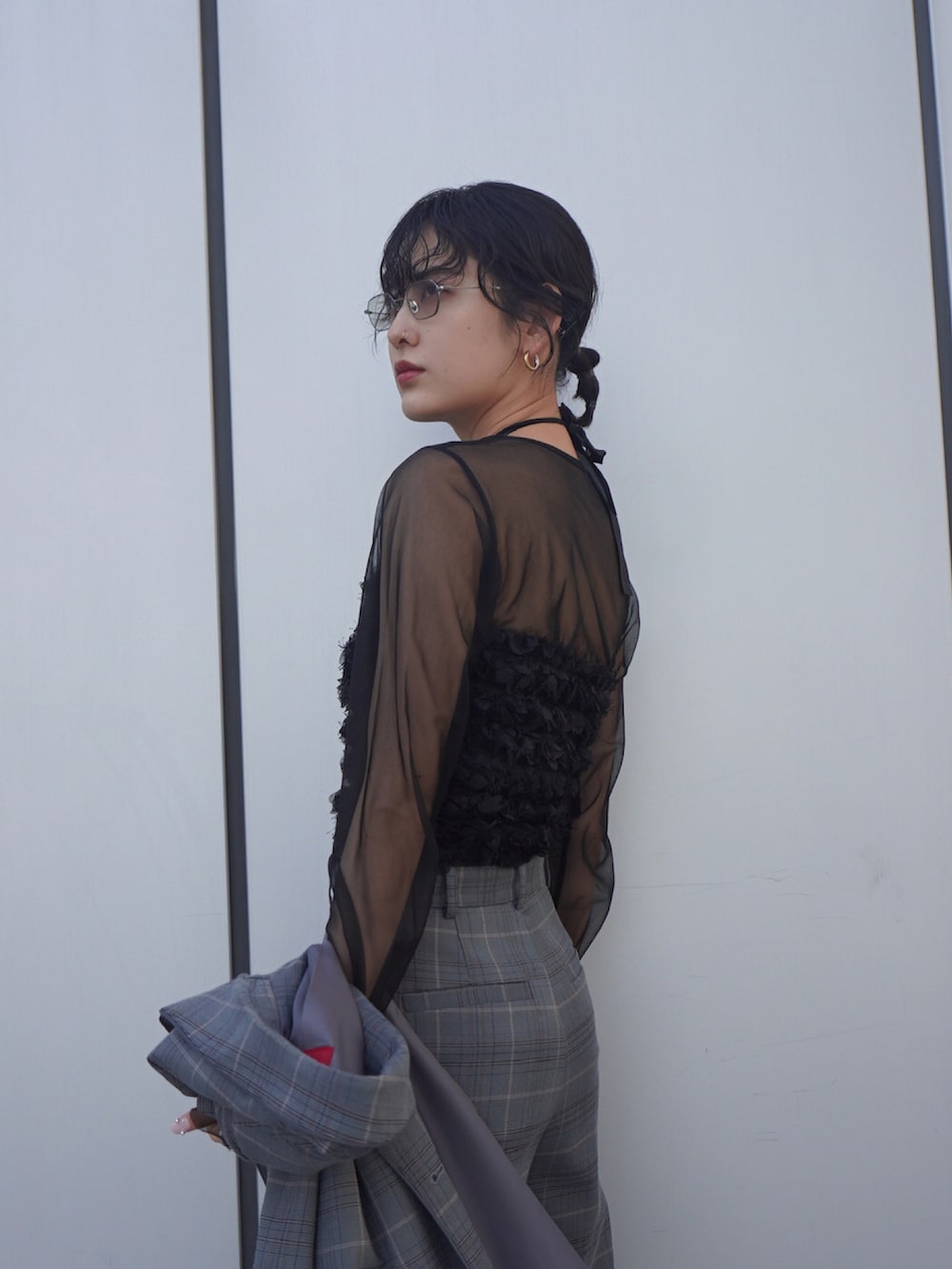 ブラック系のチューブトップ、ブラック系のトップス、グレー系のスラックスを着用したレディースの春コーディネートの2枚目の写真