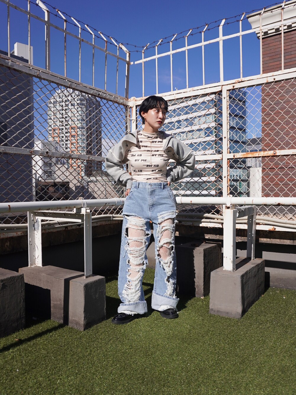 グレー系のスウェット、ブルー系のデニムパンツを着用したレディースの秋コーディネートの2枚目の写真