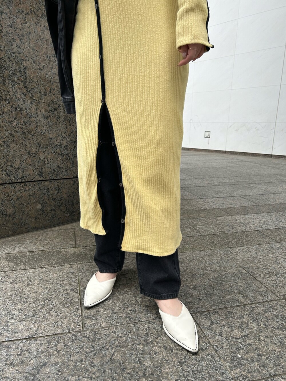 イエロー系のワンピース、ブラック系のデニムジャケットを着用したレディースの春コーディネートの2枚目の写真