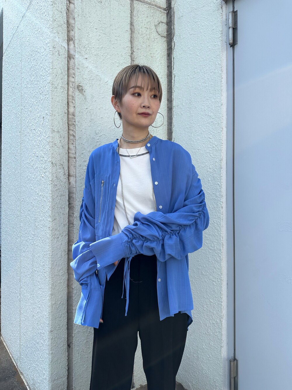 ブルー系のシャツ/ブラウス、ブラック系のスラックス、ホワイト系のタンクトップを着用したレディースの春コーディネートの2枚目の写真