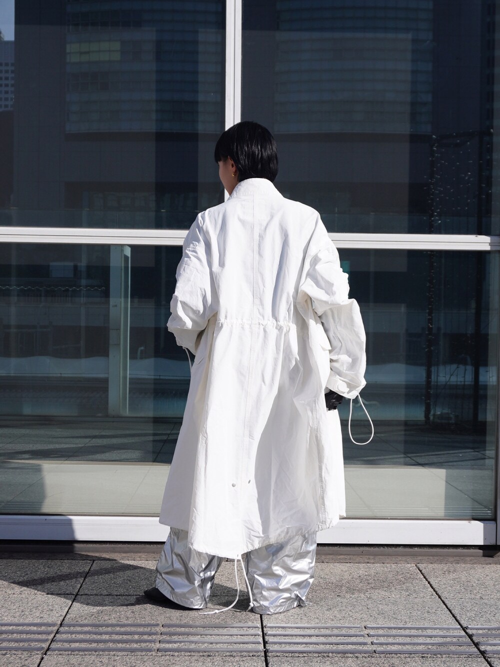 ホワイト系のミリタリージャケット、シルバー系のカーゴパンツを着用したレディースの冬コーディネートの3枚目の写真