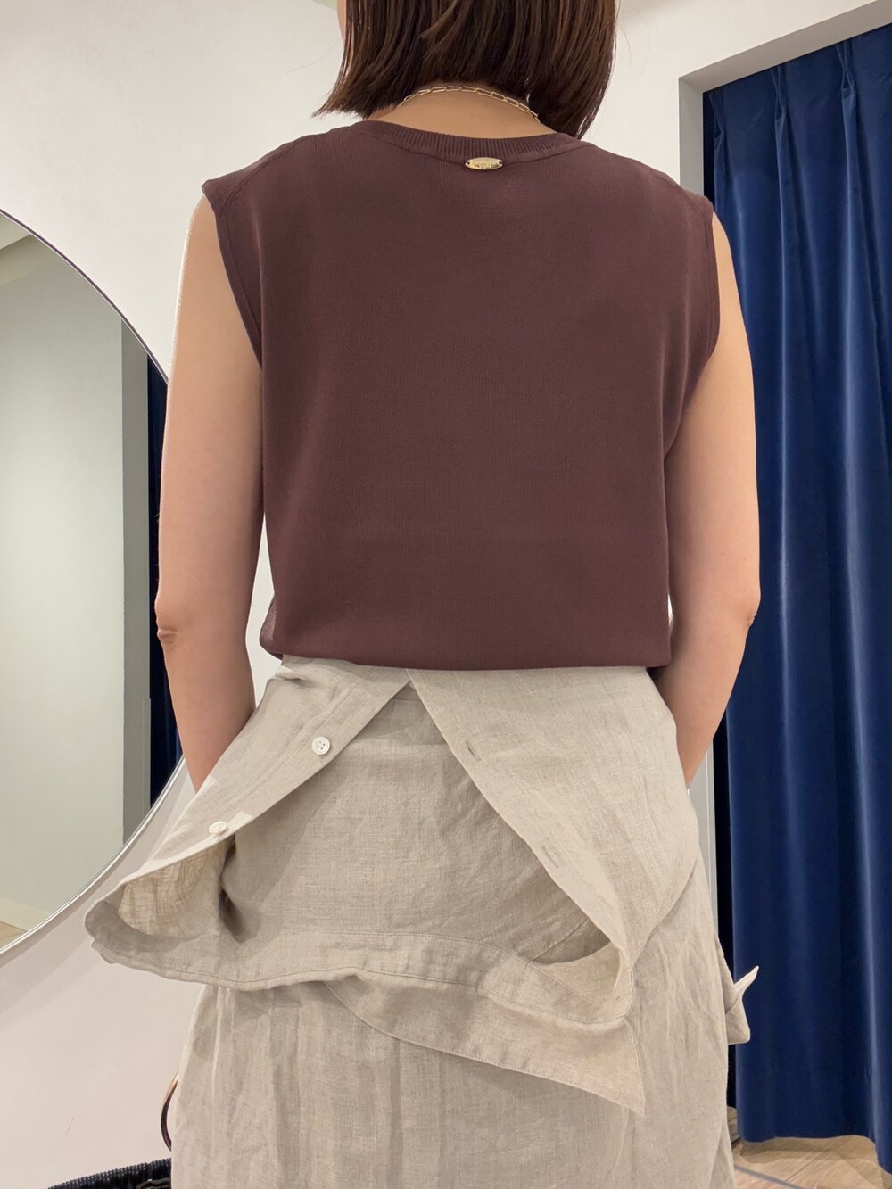 ブラウン系のニット/セーター、ベージュ系のシャツ/ブラウス、ブラック系のかごバッグを着用したレディースの夏コーディネートの8枚目の写真