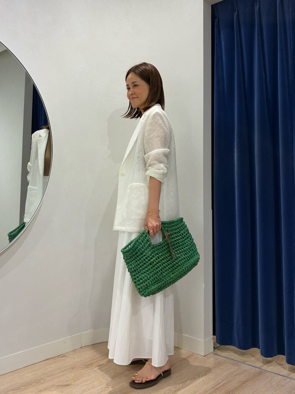 ブラウン系のタンクトップ、ホワイト系のテーラードジャケット、ホワイト系のスカートを着用したレディースの春コーディネートの4枚目の写真