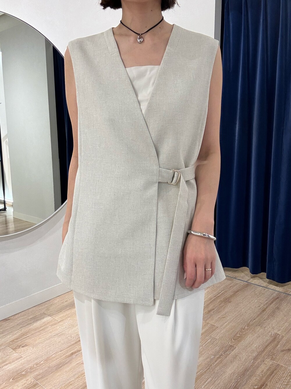 ベージュ系のベスト、ホワイト系のキャミソール、ホワイト系のその他パンツを着用したレディースの春コーディネートの7枚目の写真