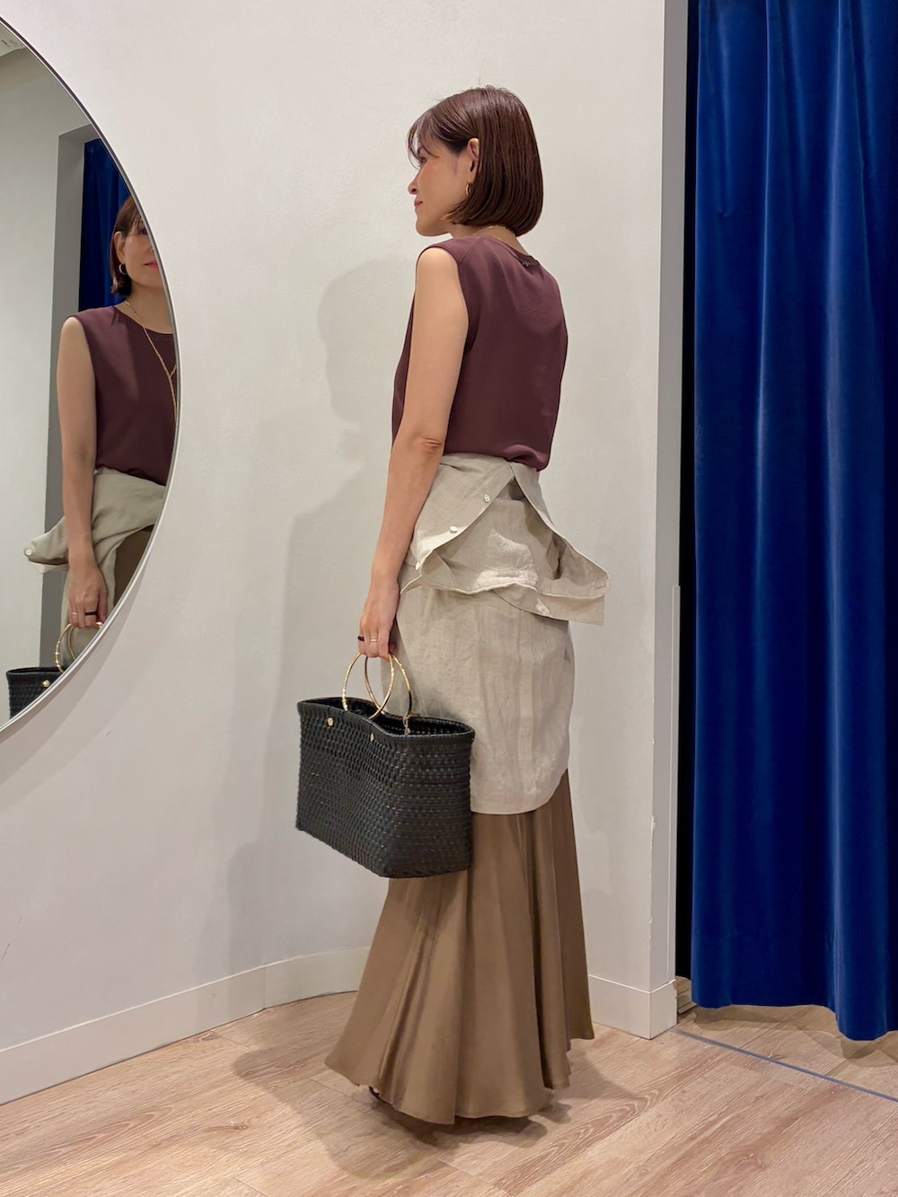 ブラウン系のニット/セーター、ベージュ系のシャツ/ブラウス、ブラック系のかごバッグを着用したレディースの夏コーディネートの3枚目の写真