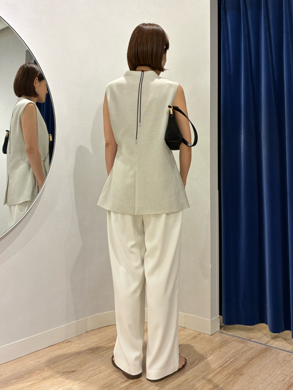 ベージュ系のベスト、ホワイト系のキャミソール、ホワイト系のその他パンツを着用したレディースの春コーディネートの3枚目の写真