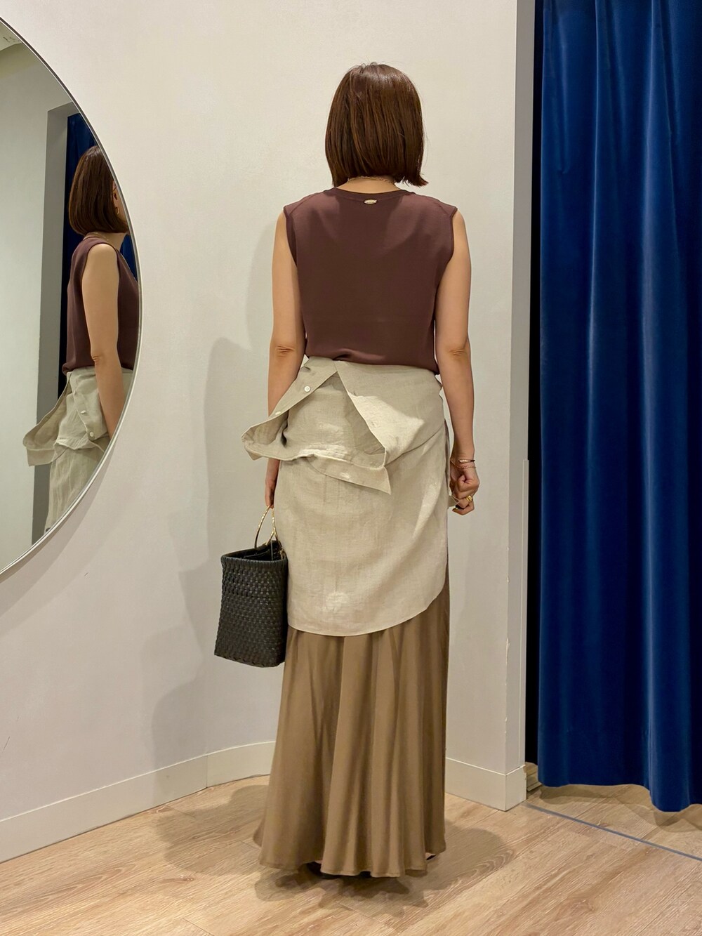 ブラウン系のニット/セーター、ベージュ系のシャツ/ブラウス、ブラック系のかごバッグを着用したレディースの夏コーディネートの4枚目の写真