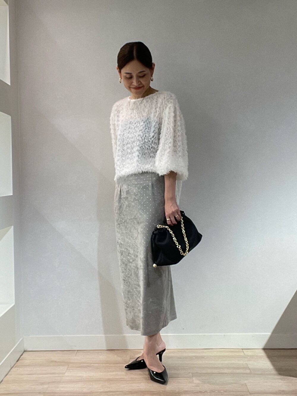 ホワイト系のシャツ/ブラウス、ベージュ系のスカート、ブラック系のショルダーバッグを着用したレディースの秋コーディネートの2枚目の写真