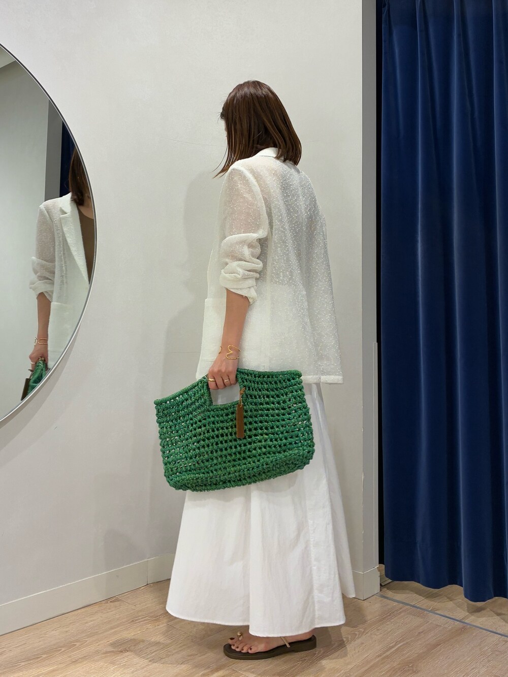 ブラウン系のタンクトップ、ホワイト系のテーラードジャケット、ホワイト系のスカートを着用したレディースの春コーディネートの5枚目の写真