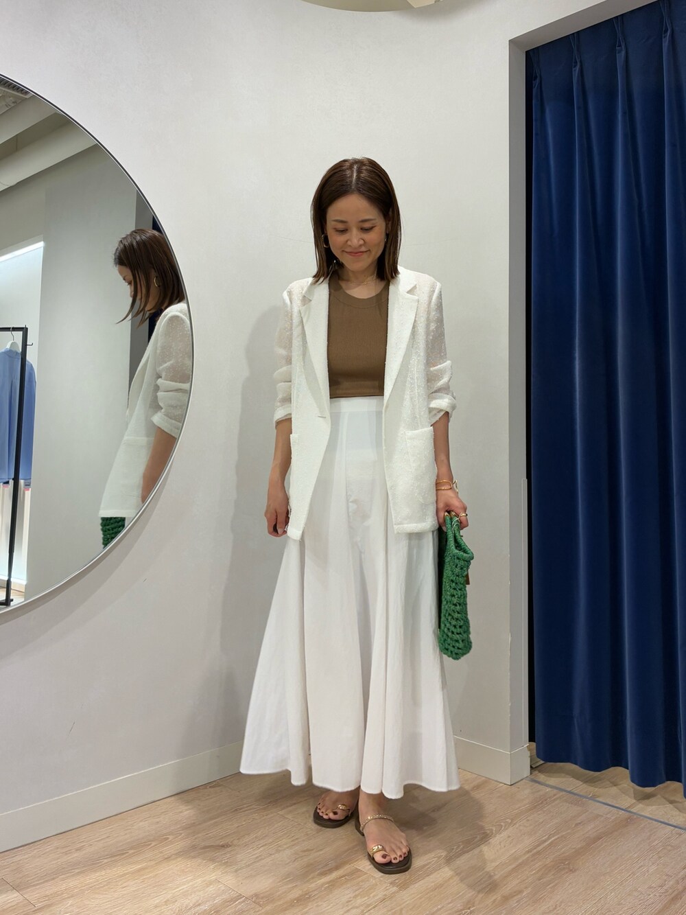 ブラウン系のタンクトップ、ホワイト系のテーラードジャケット、ホワイト系のスカートを着用したレディースの春コーディネートの6枚目の写真