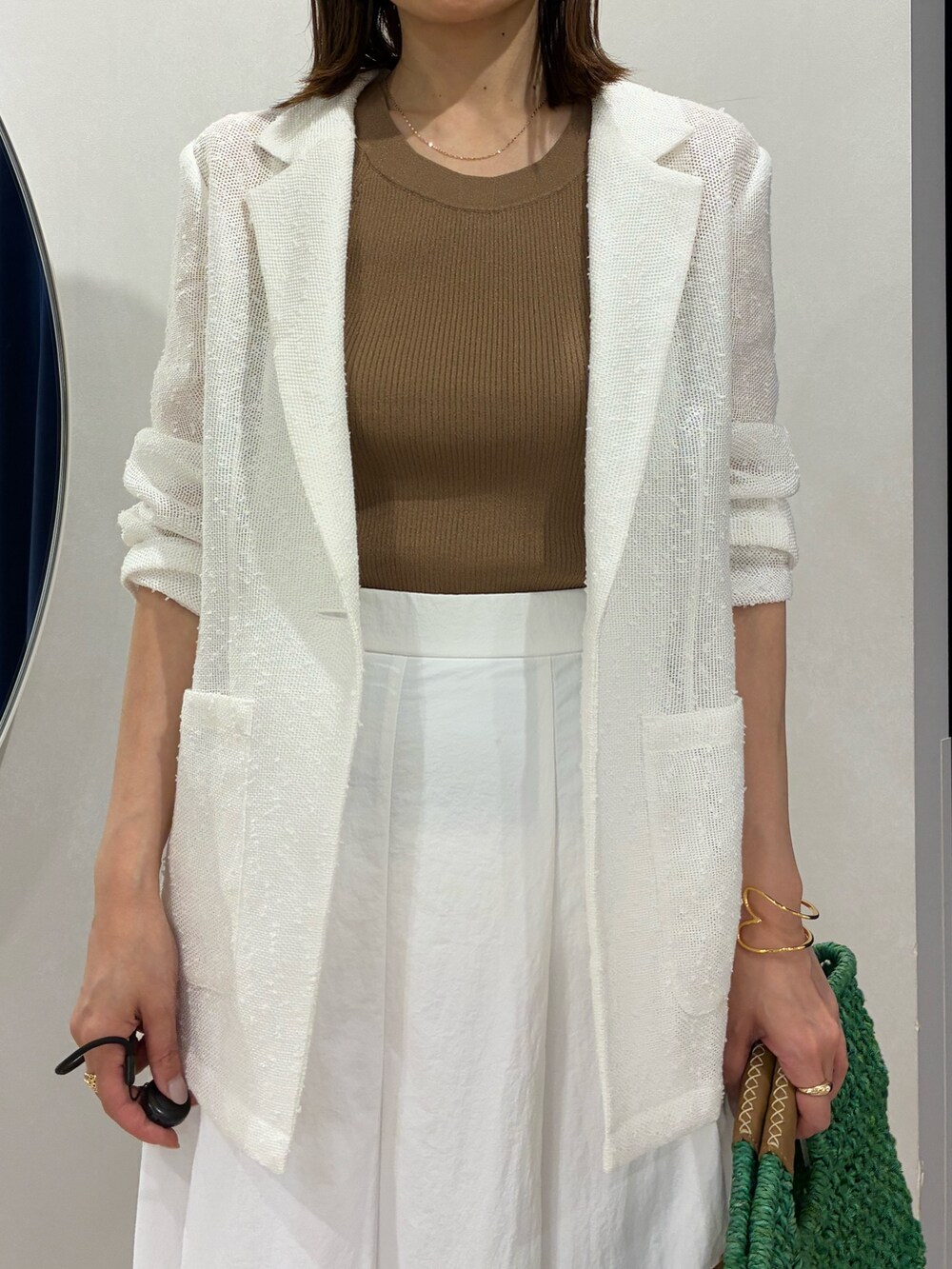 ブラウン系のタンクトップ、ホワイト系のテーラードジャケット、ホワイト系のスカートを着用したレディースの春コーディネートの8枚目の写真