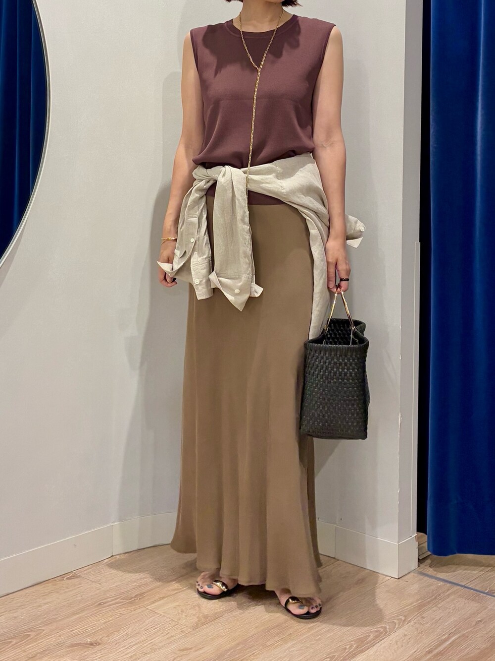 ブラウン系のニット/セーター、ベージュ系のシャツ/ブラウス、ブラック系のかごバッグを着用したレディースの夏コーディネートの6枚目の写真