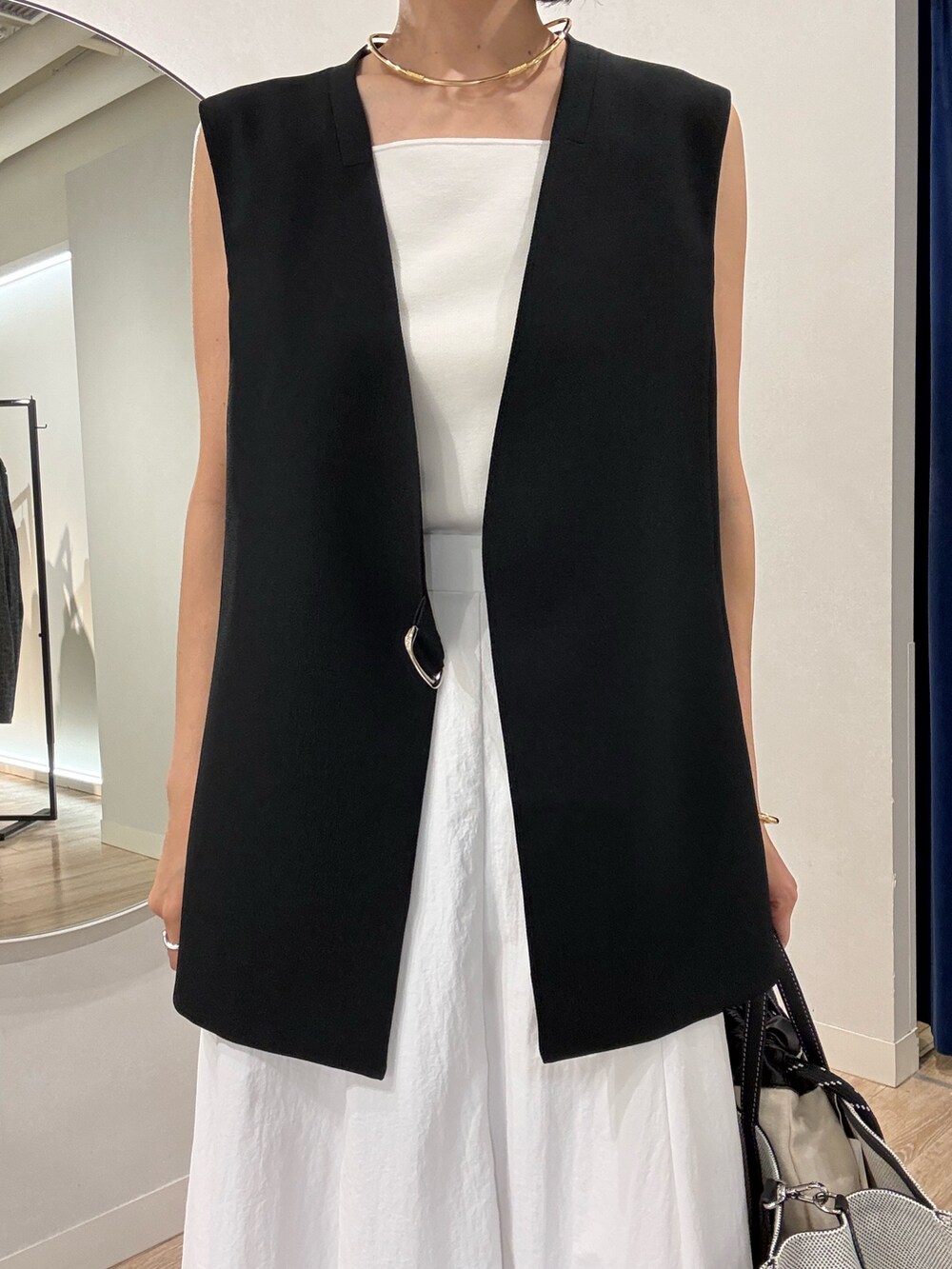 ブラック系のベスト、ホワイト系のキャミソール、ホワイト系のスカートを着用したレディースの夏コーディネートの9枚目の写真