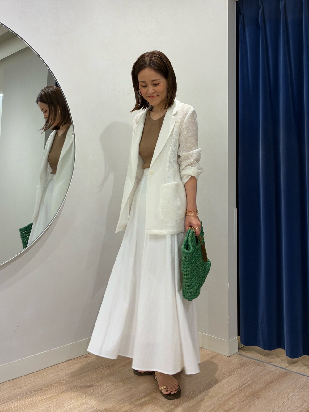 ブラウン系のタンクトップ、ホワイト系のテーラードジャケット、ホワイト系のスカートを着用したレディースの春コーディネートの7枚目の写真