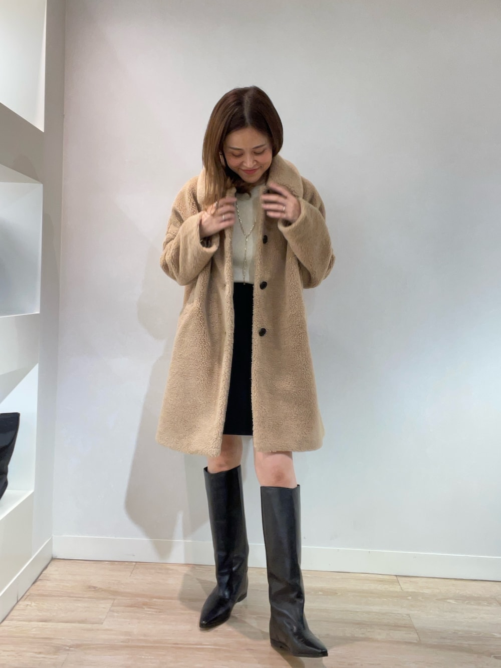 ベージュ系のブルゾン、ゴールド系のニット/セーター、ブラック系のスカートを着用したレディースの秋コーディネートの3枚目の写真