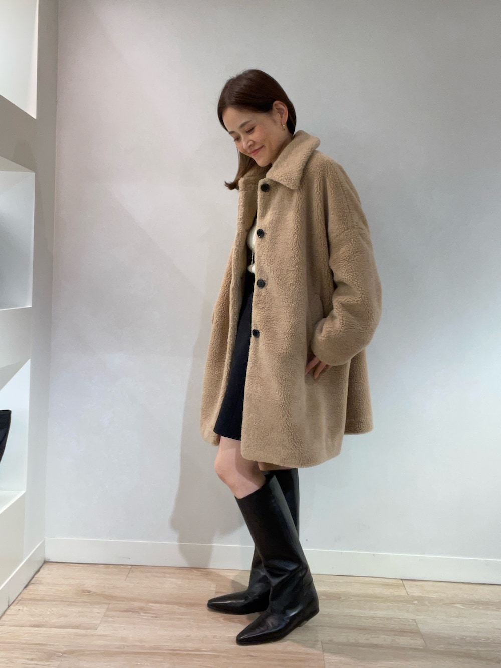 ベージュ系のブルゾン、ゴールド系のニット/セーター、ブラック系のスカートを着用したレディースの秋コーディネートの4枚目の写真