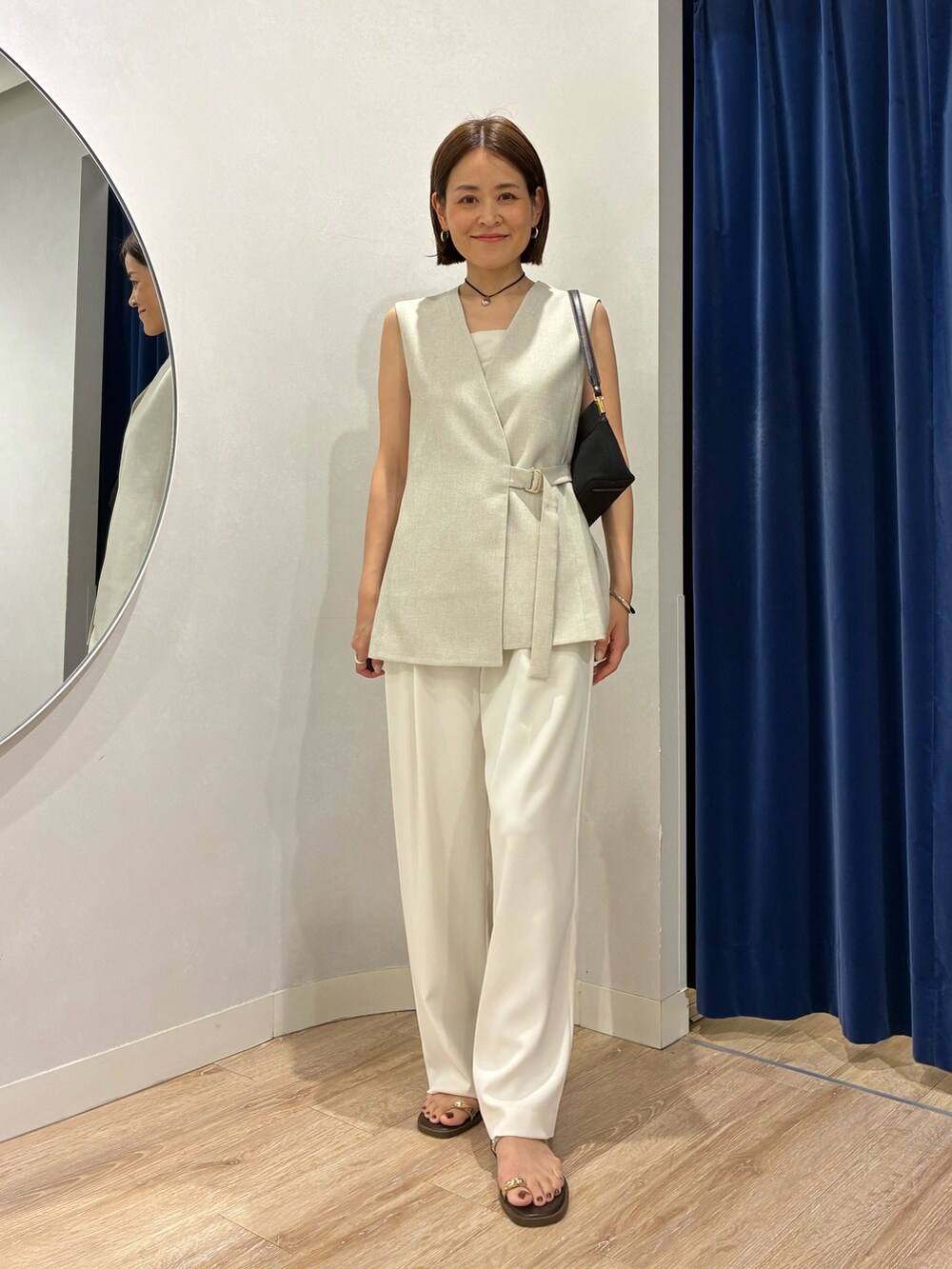 ベージュ系のベスト、ホワイト系のキャミソール、ホワイト系のその他パンツを着用したレディースの春コーディネートの2枚目の写真