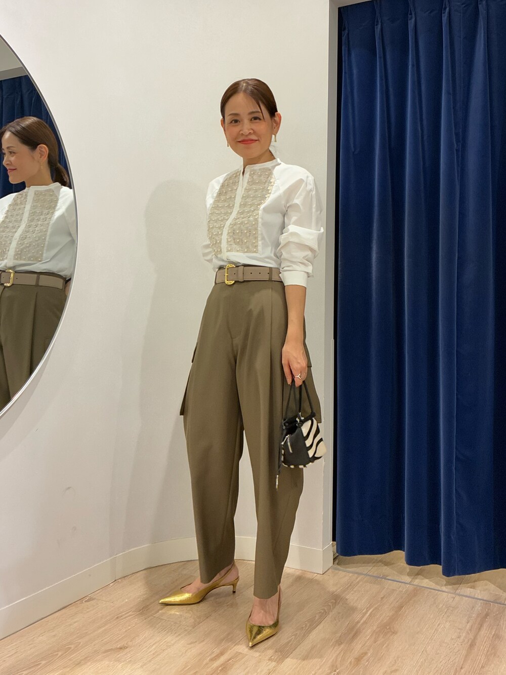 ホワイト系のシャツ/ブラウス、グリーン系のその他パンツ、その他のショルダーバッグを着用したレディースの秋コーディネートの2枚目の写真