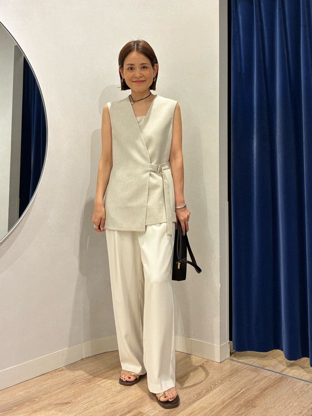ベージュ系のベスト、ホワイト系のキャミソール、ホワイト系のその他パンツを着用したレディースの春コーディネートの5枚目の写真