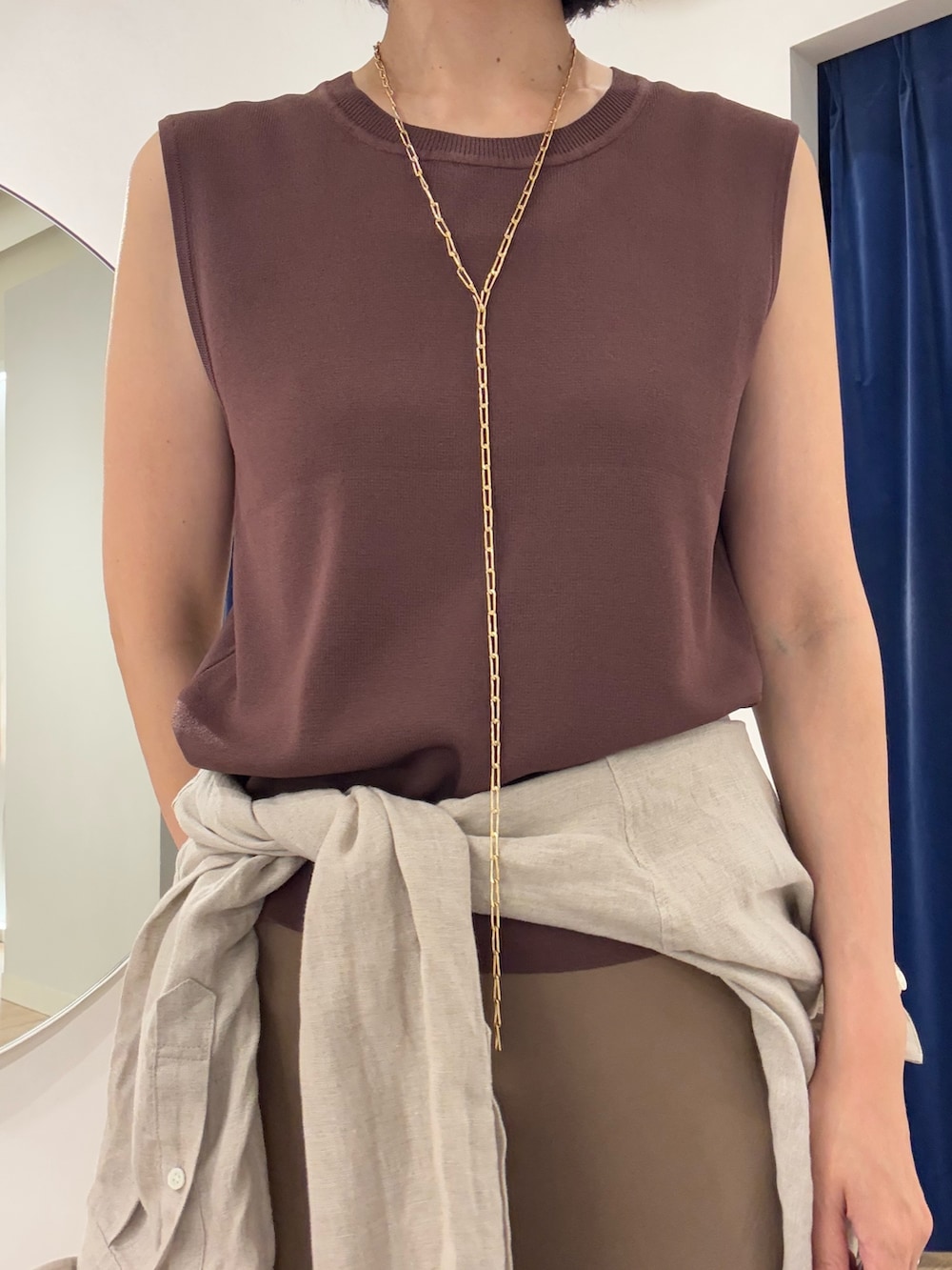 ブラウン系のニット/セーター、ベージュ系のシャツ/ブラウス、ブラック系のかごバッグを着用したレディースの夏コーディネートの7枚目の写真