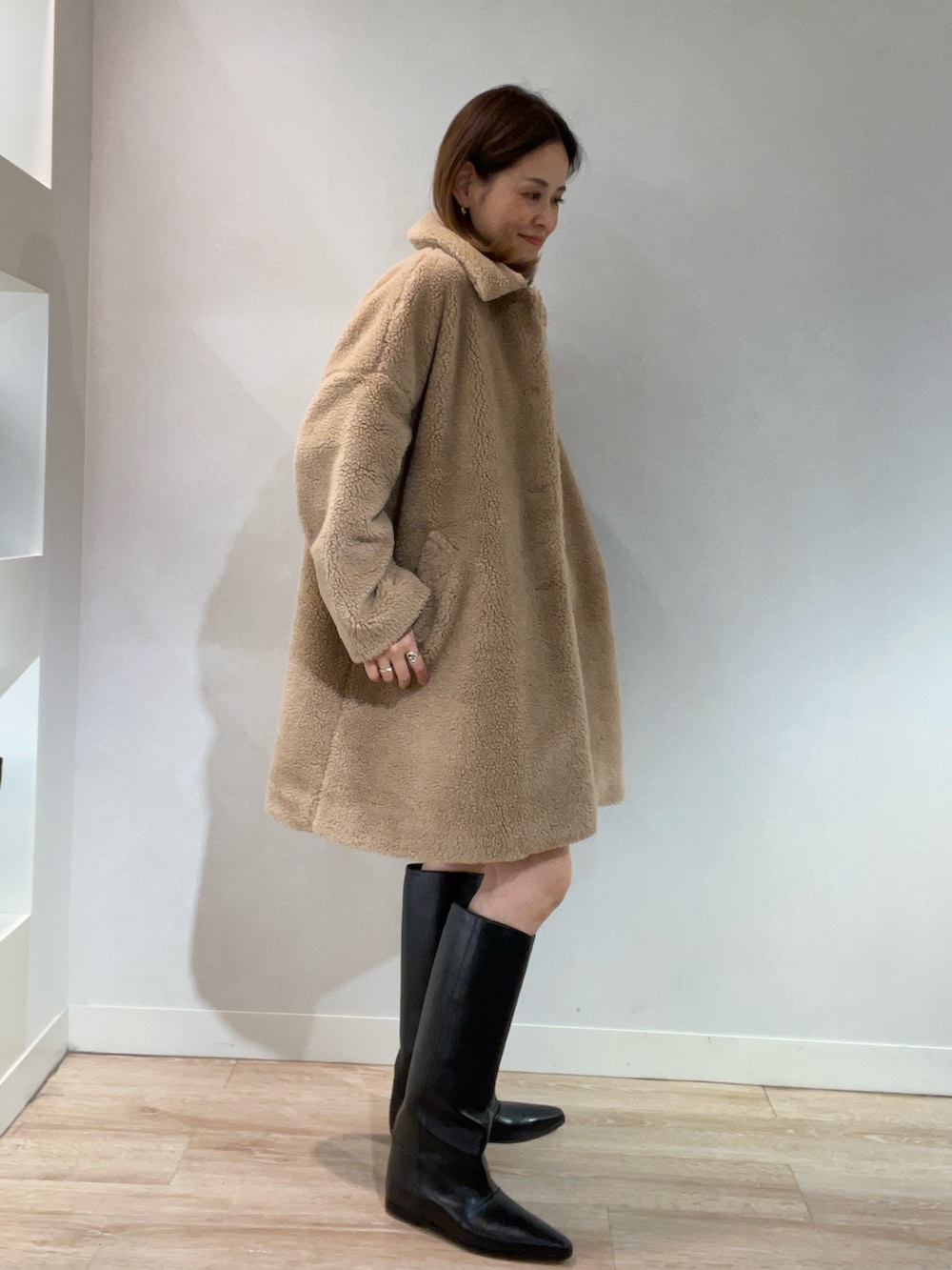 ベージュ系のブルゾン、ゴールド系のニット/セーター、ブラック系のスカートを着用したレディースの秋コーディネートの2枚目の写真