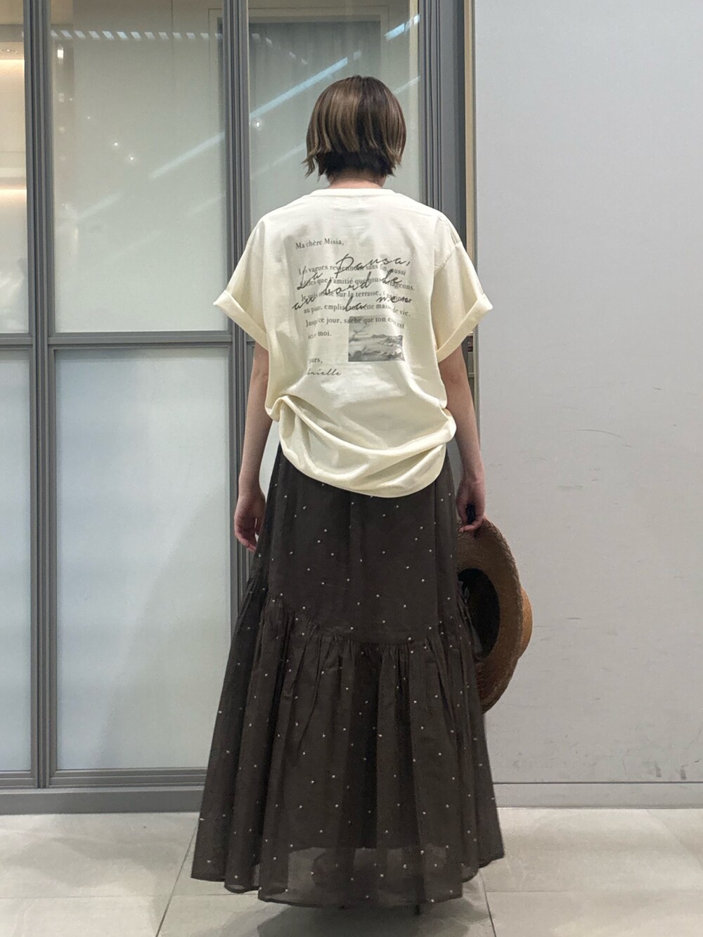 ホワイト系のTシャツ/カットソー、ブラウン系のスカート、ブラウン系のハットを着用したレディースの夏コーディネートの3枚目の写真