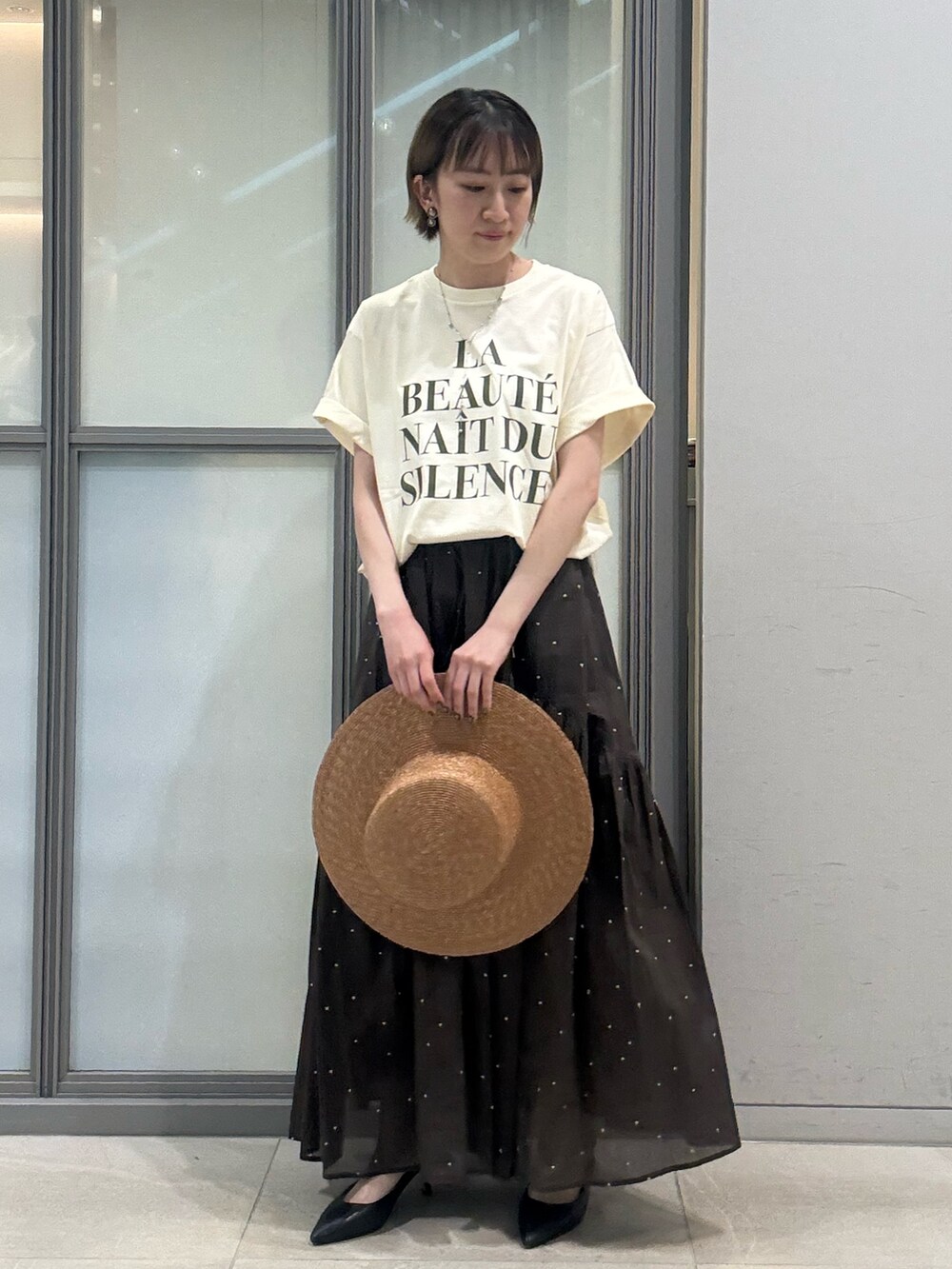 ホワイト系のTシャツ/カットソー、ブラウン系のスカート、ブラウン系のハットを着用したレディースの夏コーディネートの2枚目の写真