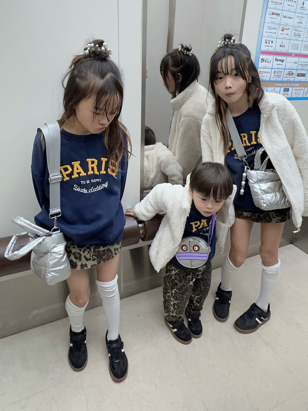 ブルー系のスウェット、ブラウン系のスカート、ブラック系のスニーカーを着用したキッズの冬コーディネートの2枚目の写真