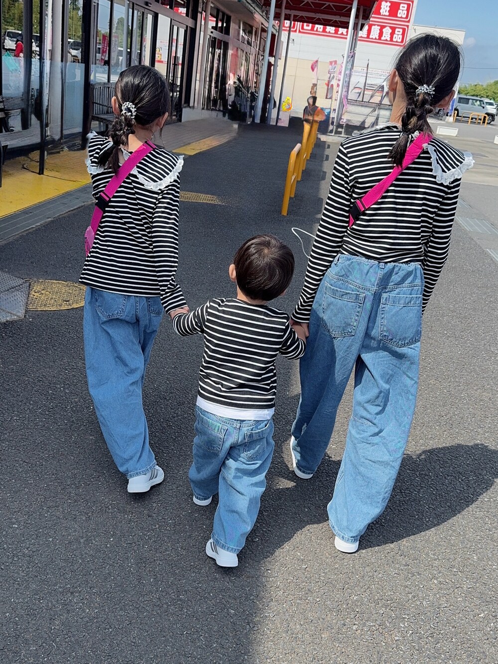 ブラック系のTシャツ/カットソー、ピンク系のショルダーバッグ、ブルー系のデニムパンツを着用したキッズの夏コーディネートの2枚目の写真