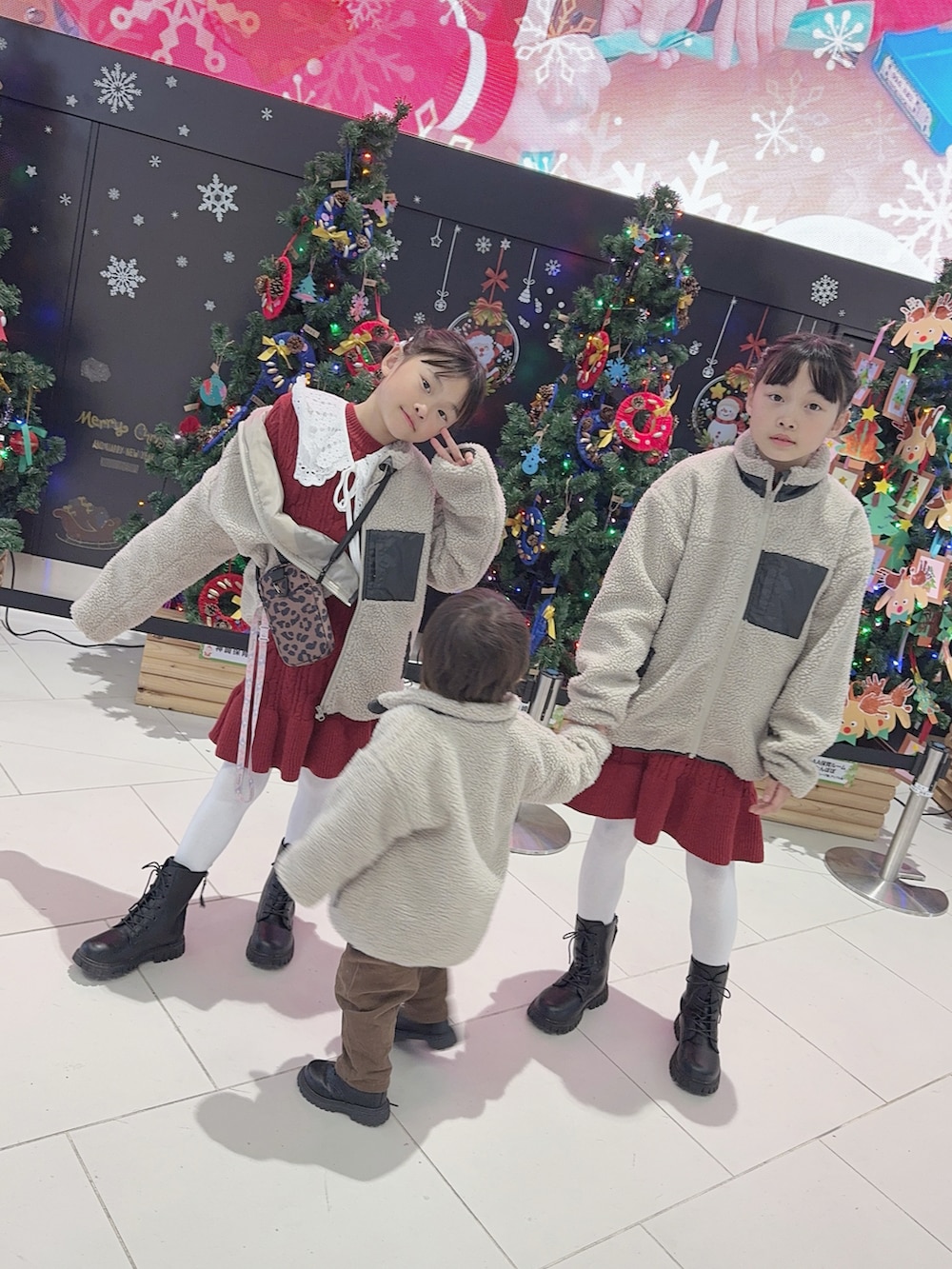 ブラック系のブーツ、ブラック系のブーツ、レッド系のワンピースを着用したキッズの冬コーディネートの3枚目の写真