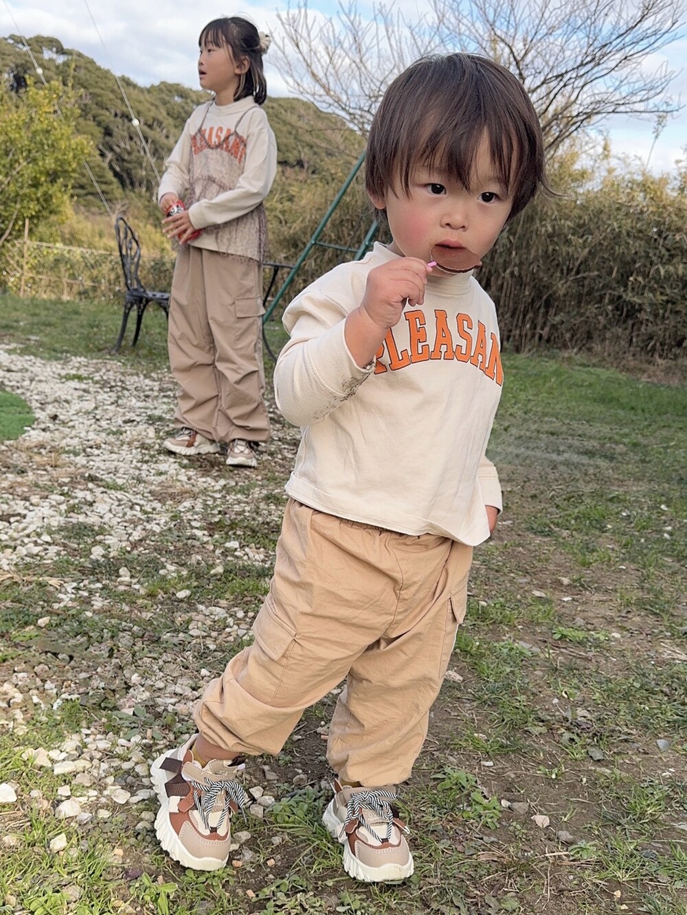 ホワイト系のTシャツ/カットソー、ブラウン系のキャミソール、ベージュ系のカーゴパンツを着用したキッズの冬コーディネートの3枚目の写真