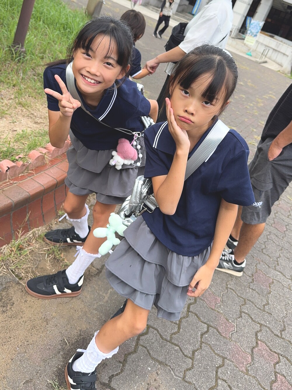 グレー系のスカート、ブルー系のポロシャツ、ブルー系のポロシャツを着用したキッズの秋コーディネートの3枚目の写真