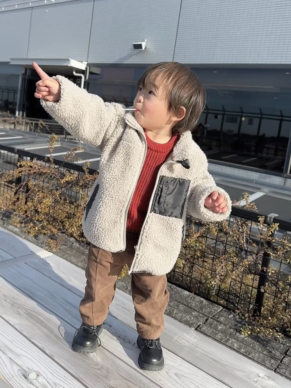 ブラック系のブーツ、ブラック系のブーツ、レッド系のワンピースを着用したキッズの冬コーディネートの4枚目の写真