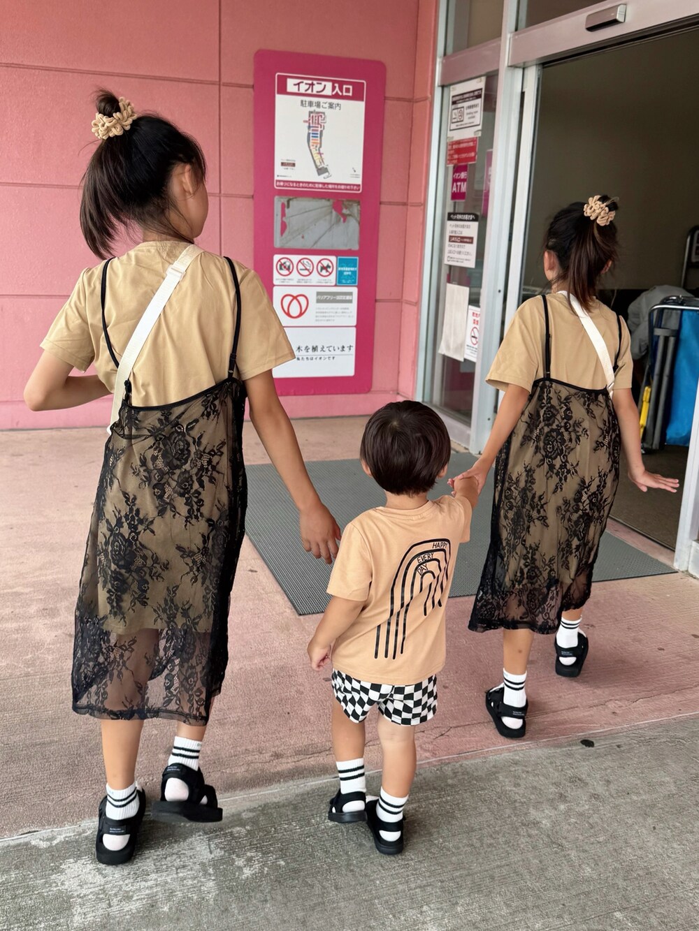 ベージュ系のTシャツ/カットソー、ベージュ系のワンピース、ブラック系のサンダルを着用したキッズの夏コーディネートの4枚目の写真