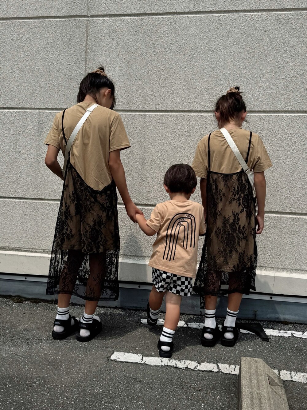 ベージュ系のTシャツ/カットソー、ベージュ系のワンピース、ブラック系のサンダルを着用したキッズの夏コーディネートの3枚目の写真