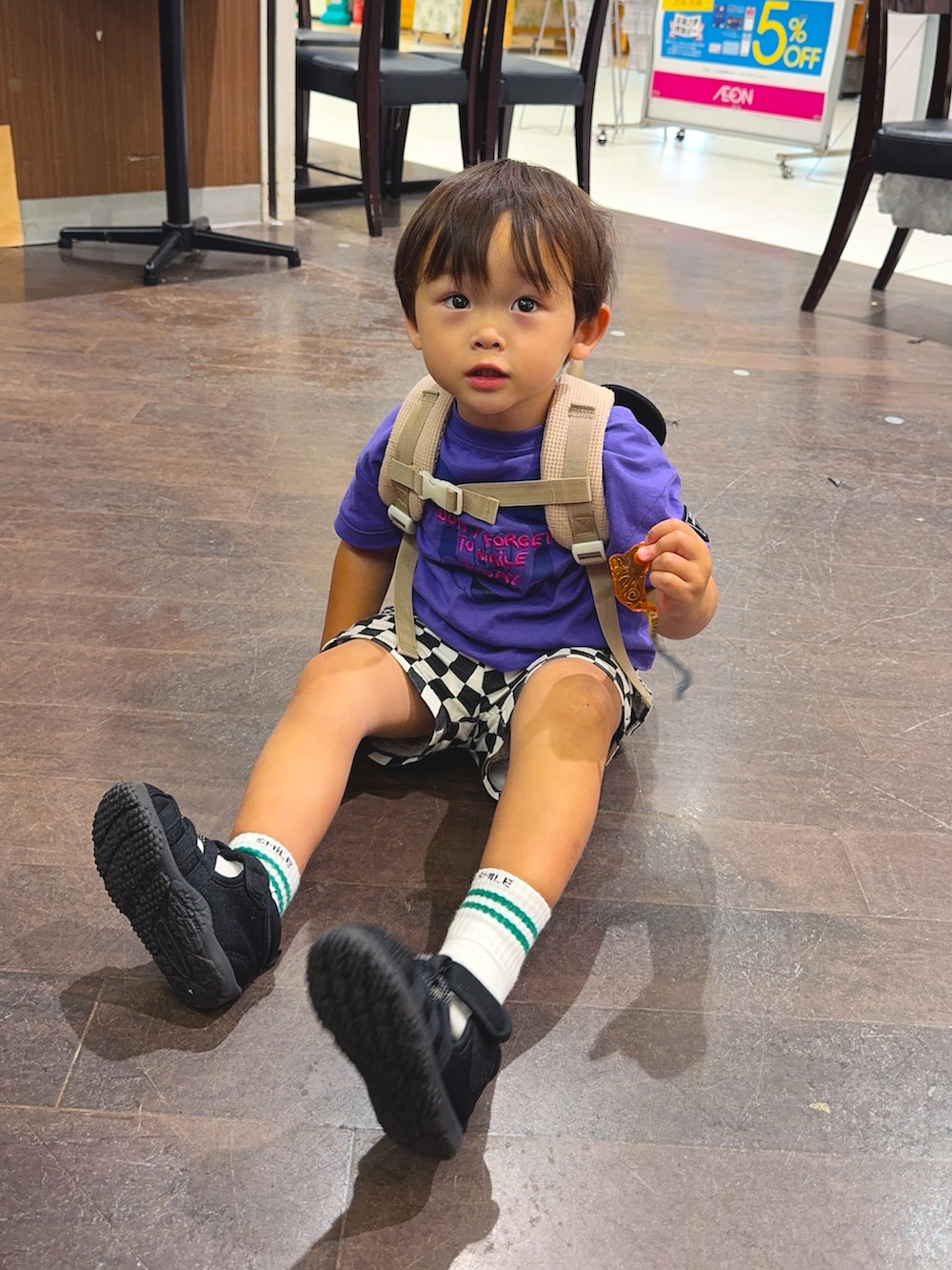 パープル系のTシャツ/カットソー、ブラック系のカーゴパンツ、ベージュ系のバックパック/リュックを着用したキッズの夏コーディネートの3枚目の写真