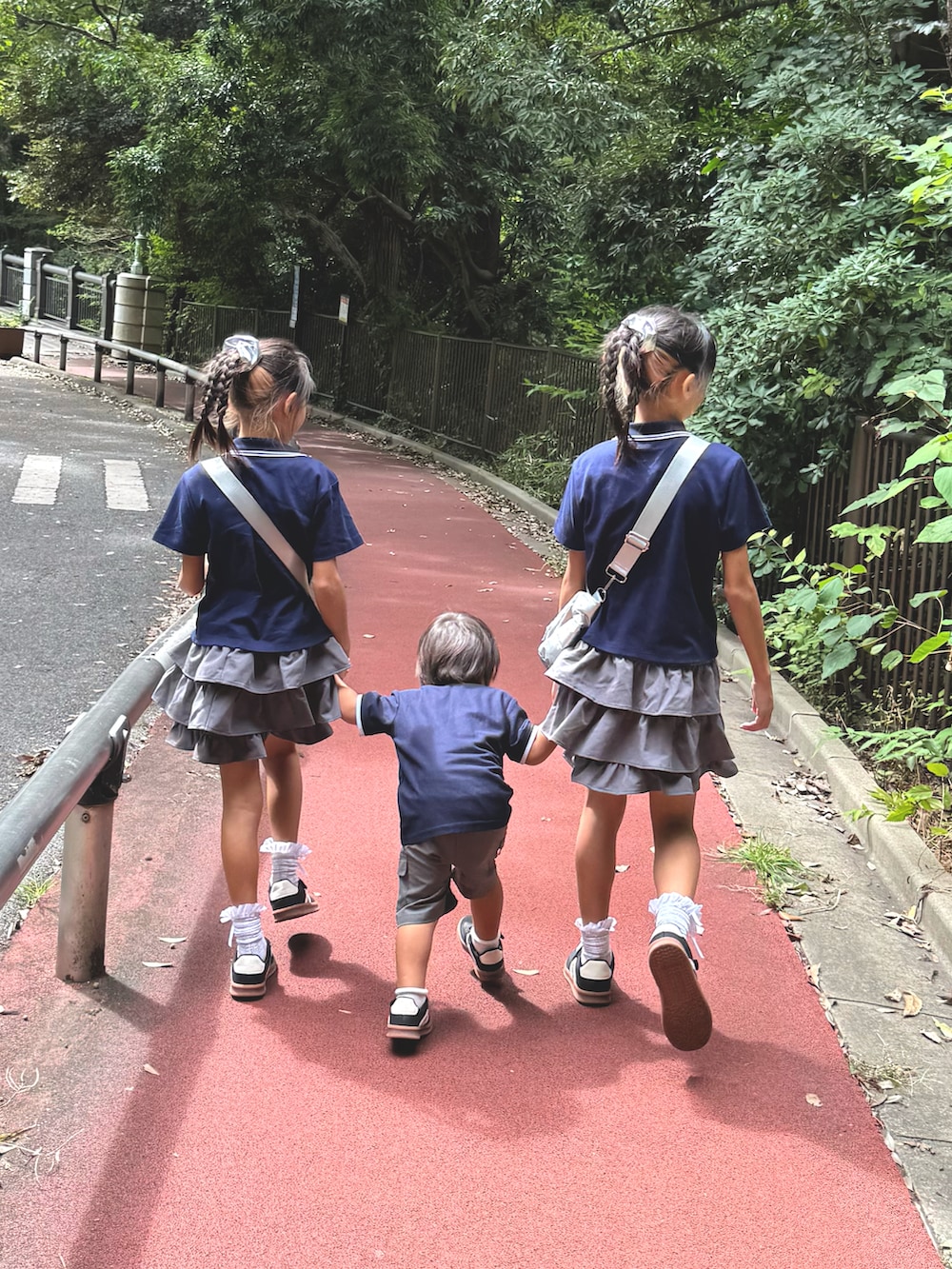 グレー系のスカート、ブルー系のポロシャツ、ブルー系のポロシャツを着用したキッズの秋コーディネートの2枚目の写真