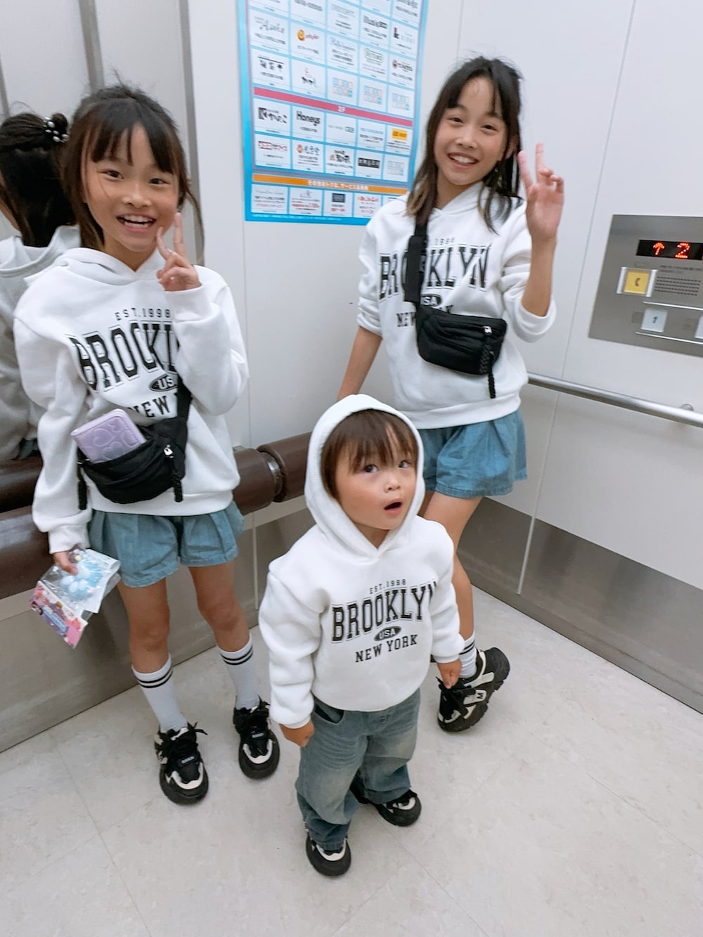 ブラック系のスニーカー、ホワイト系のスウェット、ブルー系のデニムスカートを着用したキッズの春コーディネートの2枚目の写真