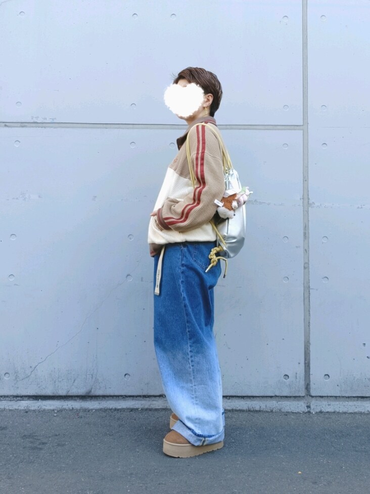 ベージュ系のセットアップ、ブルー系のデニムパンツ、ホワイト系のベルトを着用したレディースの冬コーディネートの2枚目の写真