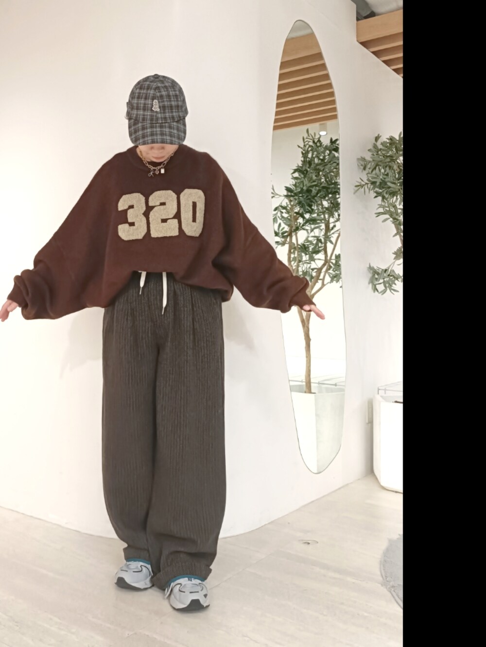 ブラウン系のニット/セーター、ブラウン系のその他パンツ、グレー系のキャップを着用したレディースの秋コーディネートの2枚目の写真