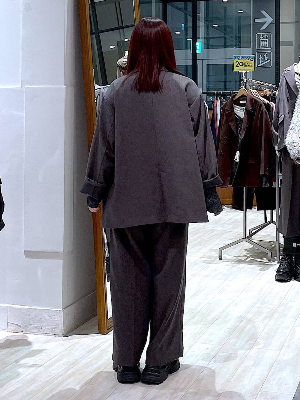 ブラック系のスニーカー、ホワイト系のTシャツ/カットソー、グレー系のテーラードジャケットを着用したレディースの秋コーディネートの4枚目の写真