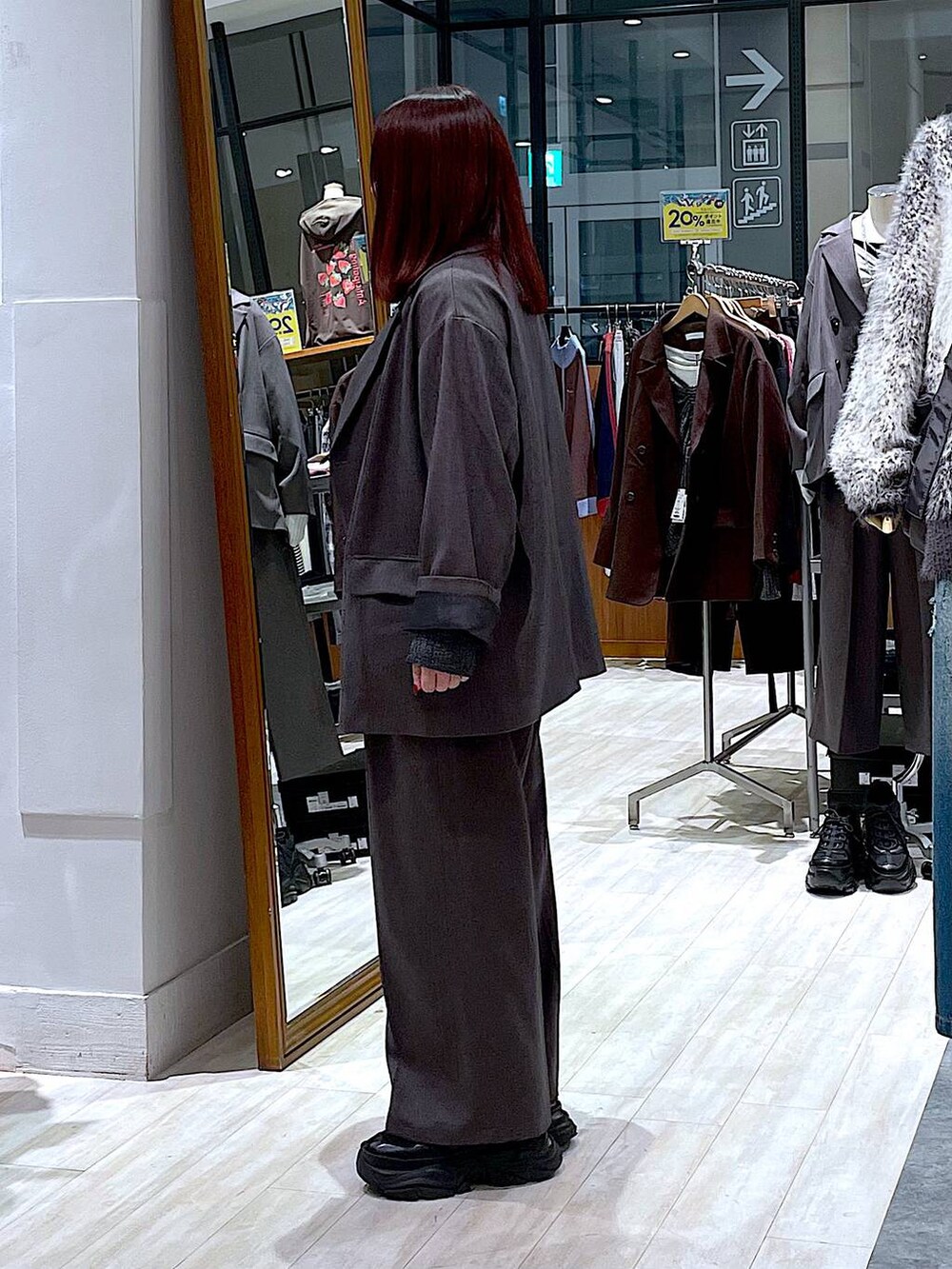 ブラック系のスニーカー、ホワイト系のTシャツ/カットソー、グレー系のテーラードジャケットを着用したレディースの秋コーディネートの2枚目の写真